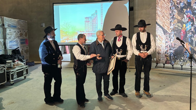 Bauherr Wolfgang Scheidtweiler bekommt von den Zimmerleuten der Baufirma den Richtspruch vorgetragen und übergeben. 