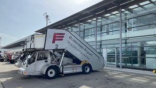 Ein Fahrzeug mit einer Fluggasttreppe am Flughafen Friedrichshafen. Wie wirkt sich die Absenkung der Luftverkehrssteuer auf die Preise für Flugtickets aus?