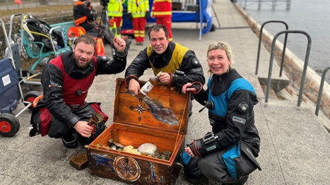 Eine Schatzkiste voller "Goldstücke" und Rum haben die Taucher beim Dreikönigstauchen vor Überlingen unter Wasser entdeckt.