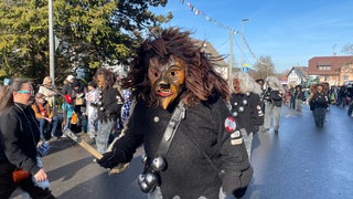 Ein wilder Maskenträger mit zersaustem Haar in Neuravensburg auf dem Narrensprung.