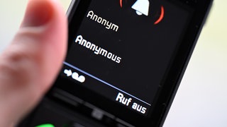 Ein Mann hält ein Festnetz-Telefon, auf dem ein anonymer Anruf eingeht. Das Polizeipräsidium Ravensburg warnt vor Kriminellen, die sich als Ärzte oder Klinikmitarbeiter ausgebe. (Symbolbild)
