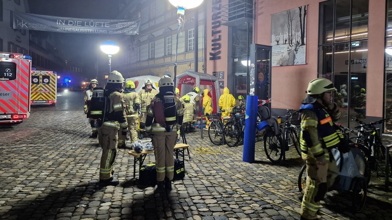 Einsatzkräfte von Feuerwehr und Rettungsdienst stehen in Schutzkleidung auf dem Münsterplatz in Konstanz.