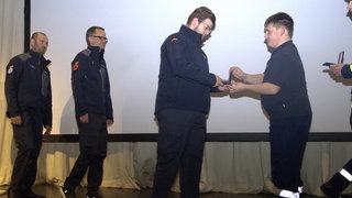 Die Bevölkerungschutz-Medaillen werden an die Einsatzkräfte übergeben.