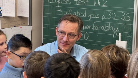 Digitaltrainer Daniel Wolff mit Schülern vor einer Tafel in der Biberacher Braithschule.