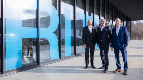 Dirk Bogen (von links), Thomas Stauber und Jürgen Nachtnebel von der Volksbank Bodensee-Oberschwaben stehen vor dem RITZ in Friedrichshafen. Sie blicken positiv auf das Jahr 2025.