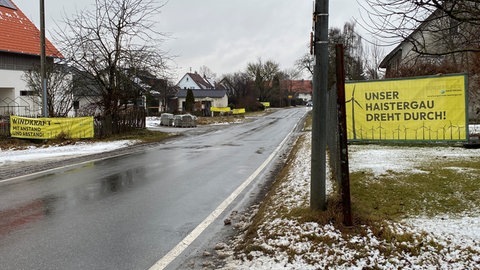 Die Hauptstraße in Osterhofen bei Bad Waldsee ist mit gelben Plakaten der Bürgerrunde Haistergau gesäumt. Sie fordern insgesamt weniger Windkraftanlagen.