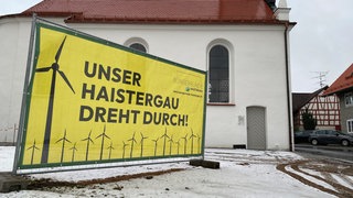 Die Hauptstraße in Osterhofen bei Bad Waldsee ist mit gelben Plakaten der Bürgerrunde Haistergau gesäumt. Sie fordern insgesamt weniger Windkraftanlagen.