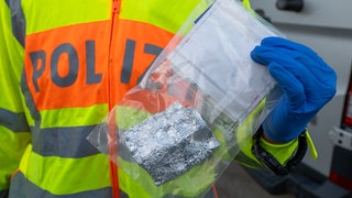 Polizei hält Tüte mit Kokain in der Hand