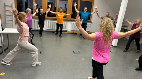 Gärtnerinnen und Gärtner bei der Aufwärmrunde ihres ungewöhnlichen Fitnesskurses an der Biberacher Obst- und Gartenbauakademie. Hier machen sie sich fit für die Gartensaison. 