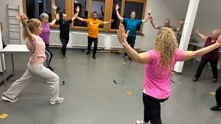 Gärtnerinnen und Gärtner bei der Aufwärmrunde ihres ungewöhnlichen Fitnesskurses an der Biberacher Obst- und Gartenbauakademie. Hier machen sie sich fit für die Gartensaison. 