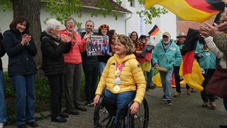 Bei der Ehrung der mehrfachen Paralympics Siegerin stehen Fans Spalier.