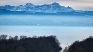 Der Berg Säntis mit seinem Masten auf dem Gipfel ragt hinter dem Bodensee über dem Dunst heraus.