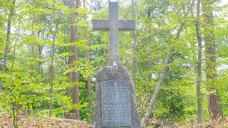 Ein Steinkreuz im Wald bei Owingen erinnert an den Tod des Zwangsarbeiters.