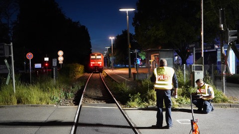 Zwei Polizisten ermitteln am Bahnübergang in Sipplingen. Ein Kind wurde hier tödlich von einem Zug erfasst.