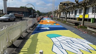 Entlang des Hafens in Konstanz sind bunte Bilder aufgemalt, man sieht sportliche Motive wie Bälle.