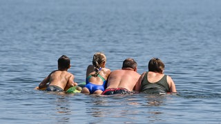 Menschen in einem Badesee: Die Badeseen in Oberschwaben und rund um den Bodensee haben fast alle eine sehr gute Wasserqualität. (Symbolbild)
