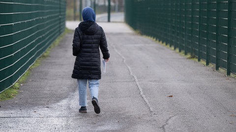 Eine Frau läuft zu ihrer Unterkunft. (Symboldbild vom 22.11.2023)