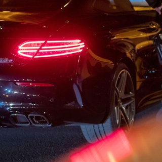 Ein Polizist kontrolliert einen getuneten Mercedes. (Symbolbild)