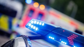 Ein Polizeiauto steht vor einem Krankenwagen.