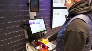 Eine Kundin scannt ein Produkt.