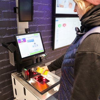 Eine Kundin scannt ein Produkt.