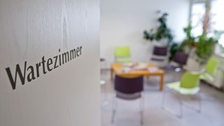 "Wartezimmer" ist auf der Tür eines leeren Wartezimmers in einer Arztpraxis zu lesen. Manche Patienten erscheinen trotz Termin einfach nicht.