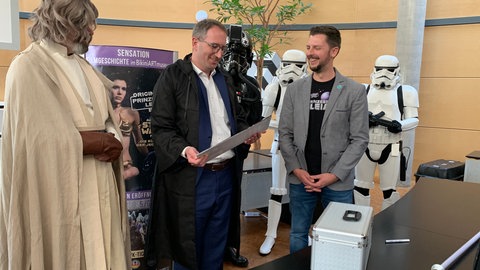 Der originale Bikini von Prinzessin Leia aus Star Wars kommt im Bad Rappenauer Rathaus an. Oberbürgermeister Sebastian Frei nimmt ihn in Empfang.