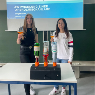Die Aperolmischmaschine: mit einer Flasche Sekt, einer Flasche Aperol und einer Flasche Sprudel.