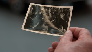 Ein Zeitzeuge hält ein Foto von 1975 des "Marschs auf Heilbronn" in der Hand.