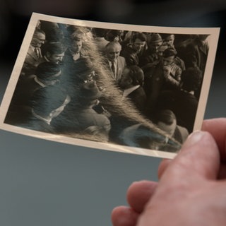 Ein Zeitzeuge hält ein Foto von 1975 des "Marschs auf Heilbronn" in der Hand.