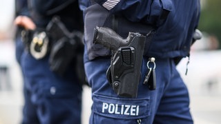 Zwei Polizisten mit Pistole und Handschellen (Symbolbild). In der City von Heilbronn ist den Beamten am Sicherheitstag 2025 ein Dealer ins Netz gegangen. Auch im Kreis Heilbronn wurde kontrolliert. 