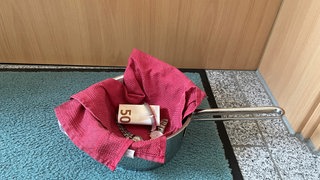 Ein Topf mit Wertsachen steht vor einer Tür (Symbolbild). Drei Gauner gingen der Polizei ins Netz, die sich auf diese Weise Beute übergeben ließen.