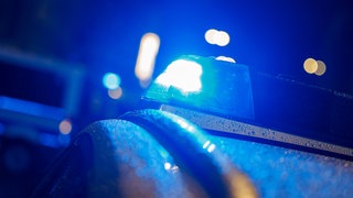 Blaulicht eines Polizeiautos (Symbolbild). Nach einem Überfall auf eine Tankstelle in Neckarsulm ist der Täter flüchtig. Er trug einen Motorradhelm.