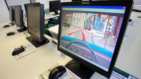 Auf Bildschirmen ist in einem Prüfungszimmer eine Prüfungsfrage zu sehen (Symbolbild). Eine Fahrschule in Heilbronn hat im großen Stil bei der Theorieprüfung betrogen. Das Netzwerk flog jetzt auf.