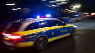 Ein Polizeiauto bei Nacht (Symbolbild). Im vergangenen Dezember soll sich ein junger Mann mit der Polizei eine Verfolgungsjagd in Heilbronn geliefert haben. Jetzt steht er vor Gericht.