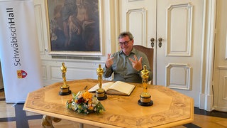 Der dreifache Oscargewinner Gerd Nefzer aus Schwäbisch Hall trägt sich in das Goldene Buch der Stadt ein.