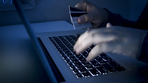 Ein Mann tätigt eine Überweisung an seinem Laptop (Symbol): Kriminelle bringen Privatanleger um ihr Erspartes. Ein Eherpaar aus Heilbronn verliert 400.000 Euro durch Krypto-Betrug.