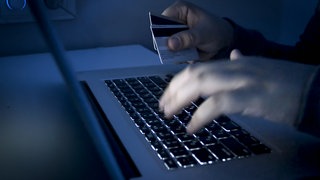 Ein Mann tätigt eine Überweisung an seinem Laptop (Symbol): Kriminelle bringen Privatanleger um ihr Erspartes. Ein Eherpaar aus Heilbronn verliert 400.000 Euro durch Krypto-Betrug.
