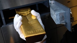 Goldbarren wird in ein Schließfach gelegt