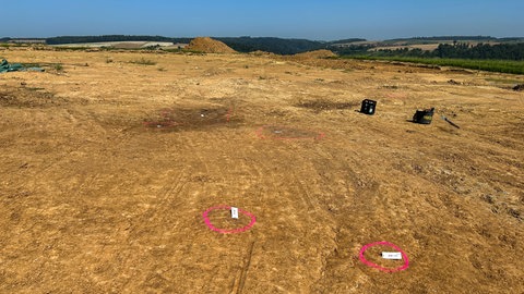 Mit pinker Farbe sind dunklere Stellen im Boden markiert. Bei Grabungen für "SuedLink" bei Neudenau haben die Archäologen Stellen entdeckt, an denen mal die Pfosten eines Hauses standen.