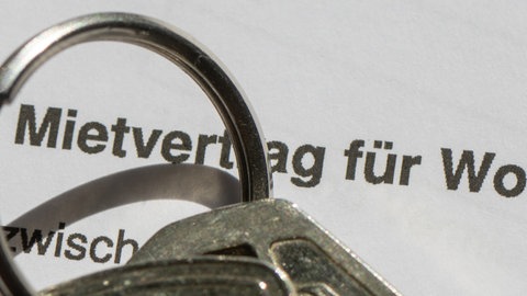 Ein Wohnungsschlüssel liegt auf einem Mietvertrag für eine Wohnung.