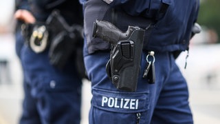 Zwei Polizisten mit Dienstwaffen (Symbolbild): In Niedernhall rückte die Polizei aus, weil ein Jugendlicher ein Mädchen mit einer Waffe bedroht hatte. Anschlißend gab er Schüsse in einen Bus ab.