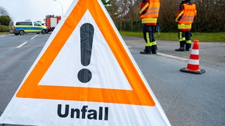 Ein Warndreieck steht nach einem Unfall (Symbolbild). Unter einer Brücke bei Untergruppenbach sind zwei Autos zusammen gekracht und gegen die Betonwand geprallt. Ein Fahrer wurde eingeklemmt.
