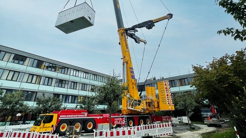 Das erste Modul wird mit dem Schwerlastkran auf die Kinderklinik gesetzt: Die Bethesda-Schule im SLK-Klinikum bekommt einen Neubau. Dort werden Kinder bei längeren Krankenhausaufenthalten unterrichtet.
