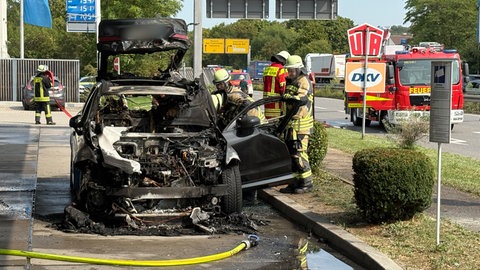 Ein ausgebranntes Auto an Neckarsulmer Tankstelle (Archivbild). Vor gut einem Monat ist an einer Tankstelle in Neckarsulm ein Hybridauto in Flammen aufgegangen. Die Polizei hat nun die Ursache ermittelt. 
