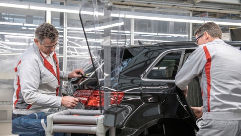 Zwei Produktionsmitarbeiter in einer Audi-Fertigungshalle (Symbol): Noch läuft die Produktion am Standort in Neckarsulm.