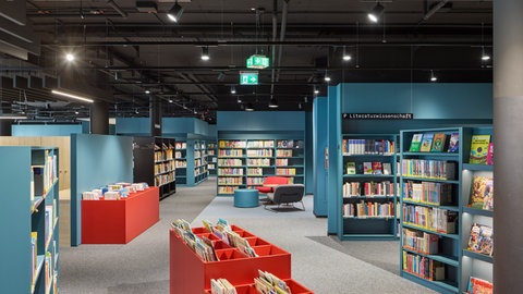 Die moderne Innenarchitektur der Heilbronner Stadtbibliothek mit petrolblauen und orangenen Farbakzente begeistert Besucherinnen und Besucher. Die Bibliothek ist ein Ort zum Verweilen geworden. 