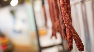 Würstchen hängen in einer Metzgerei.