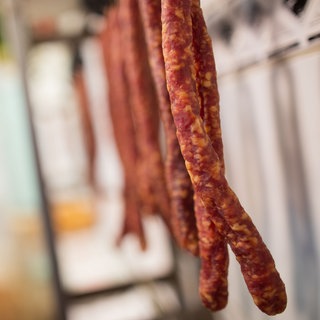 Würstchen hängen in einer Metzgerei.