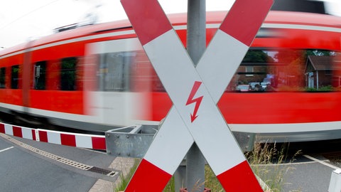 Ein Zug passiert einen Bahnübergang mit einem Andreaskreuz 